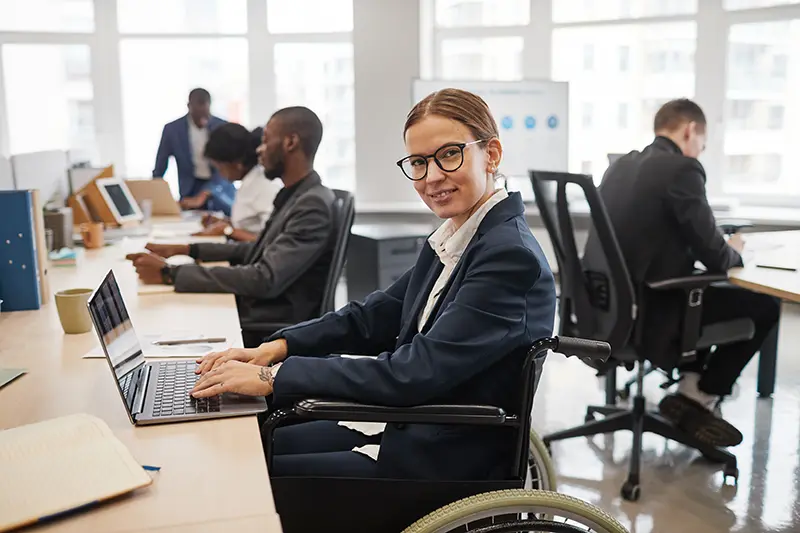 Administrative professional working at a laptop in a modern Dallas office, representing workplace staffing solutions