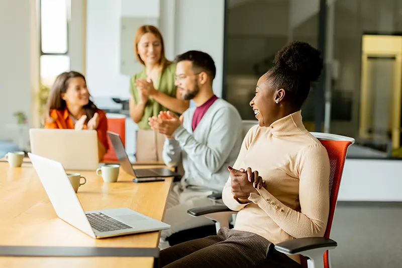 Dallas job seeker smiling during a temp agency placement meeting with colleagues in a modern office